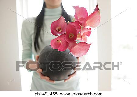 Mid section view of a woman holding flowers in a vase View Large Photo Image Stock Photography - Mid section view of a woman holding flowers in a vase. Fotosearch