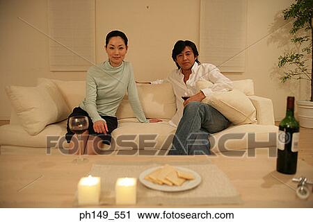 Portrait of a young couple sitting on a couch View Large Photo Image Stock Image - Portrait of a young couple sitting on a couch. Fotosearch