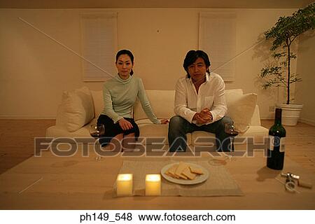 Portrait of a young couple sitting on a couch View Large Photo Image Stock Photo - Portrait of a young couple sitting on a couch. Fotosearch