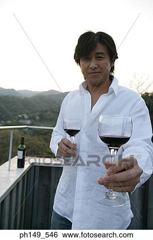 Portrait of a young man holding wineglasses View Large Photo Image Stock Photograph - Portrait of a young man holding wineglasses. Fotosearch