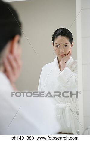 Download Rear view of a young woman in front of a mirror Stock ...