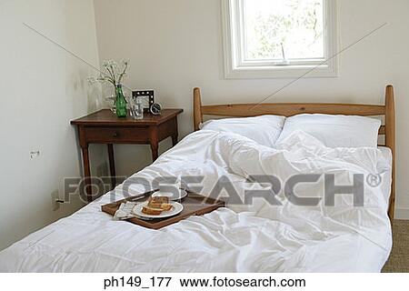 Serving tray with a tea cup and a plate on the bed View Large Photo Image Stock Photo - Serving tray with a tea cup and a plate on the bed. Fotosearch