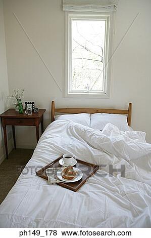 Serving tray with a tea cup and a plate on the bed View Large Photo Image Stock Photo - Serving tray with a tea cup and a plate on the bed. Fotosearch