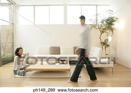 Side profile of a man walking with a young woman sitting on the floor View Large Photo Image Stock Photo - Side profile of a man walking with a young woman sitting on the floor. Fotosearch