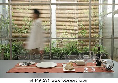 Side profile of a person walking near a dining table View Large Photo Image Stock Image - Side profile of a person walking near a dining table. Fotosearch