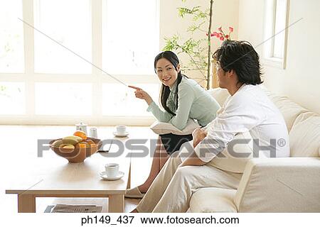 Side profile of a young couple sitting on a couch and smiling View Large Photo Image Stock Photo - Side profile of a young couple sitting on a couch and smiling. Fotosearch