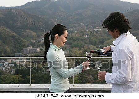 Side profile of a young man pouring red wine into a young woman's glass View Large Photo Image Stock Image - Side profile of a young man pouring red wine into a young woman's glass. Fotosearch