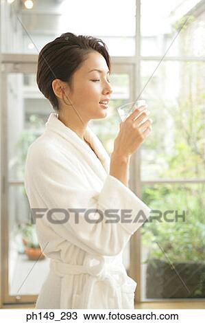 Side profile of a young woman drinking a glass of water View Large Photo Image Stock Image - Side profile of a young woman drinking a glass of water. Fotosearch