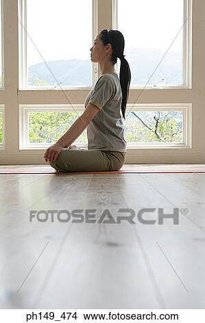 Side profile of a young woman practicing yoga View Large Photo Image Picture - Side profile of a young woman practicing yoga. Fotosearch