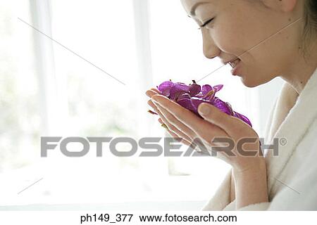Side profile of a young woman smelling a handful of flowers View Large Photo Image Stock Photo - Side profile of a young woman smelling a handful of flowers. Fotosearch