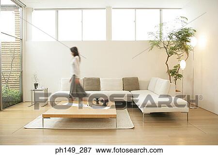 Side profile of a young woman walking in the living room View Large Photo Image Stock Photo - Side profile of a young woman walking in the living room. Fotosearch