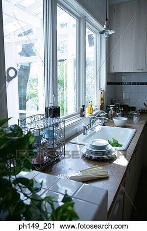 Stack of plates and pasta near a kitchen sink View Large Photo Image Stock Image - Stack of plates and pasta near a kitchen sink. Fotosearch