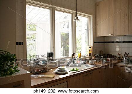Stock Image - Stack of plates and pasta near a kitchen sink. Fotosearch