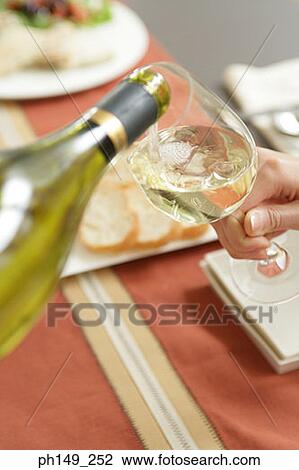 White wine being poured into a wine glass View Large Photo Image Stock Image - White wine being poured into a wine glass. Fotosearch