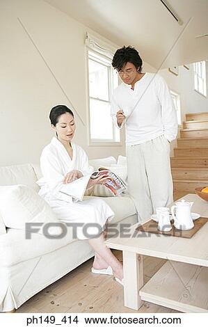 Young couple reading a magazine View Large Photo Image Picture - Young couple reading a magazine. Fotosearch