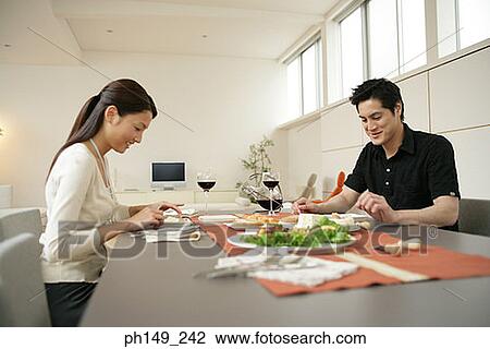 Young couple sitting at the dining table View Large Photo Image Stock Image - Young couple sitting at the dining table. Fotosearch
