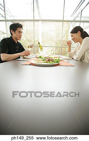 Young couple sitting at the dining table View Large Photo Image Stock Photography - Young couple sitting at the dining table. Fotosearch