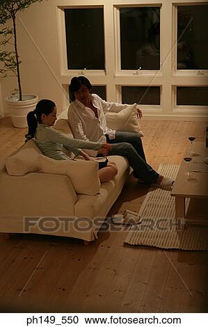 Young couple sitting on a couch View Large Photo Image Stock Image - Young couple sitting on a couch. Fotosearch