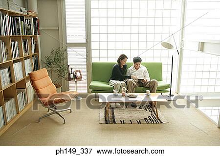 Stock Photo - Young couple sitting on a couch. Fotosearch