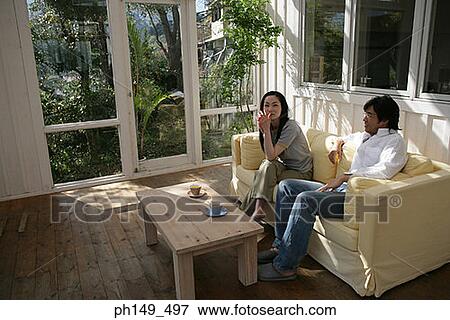 Young couple sitting on a couch View Large Photo Image Stock Photo - Young couple sitting on a couch. Fotosearch