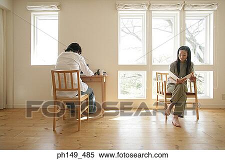 Young couple sitting on chairs View Large Photo Image Stock Photography - Young couple sitting on chairs. Fotosearch