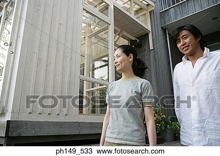 Young couple standing and smiling View Large Photo Image Stock Image - Young couple standing and smiling. Fotosearch