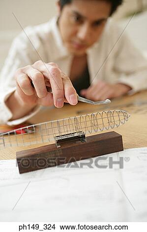 Young man assembling a model of an airship View Large Photo Image Picture - Young man assembling a model of an airship. Fotosearch