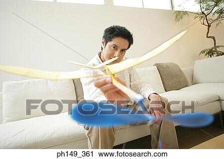 Young man holding an paper airplane View Large Photo Image Stock Image - Young man holding an paper airplane. Fotosearch