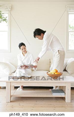 Young man pointing towards a magazine held by a young woman View Large Photo Image Stock Image - Young man pointing towards a magazine held by a young woman. Fotosearch