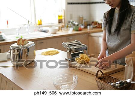 Young woman kneading pasta dough in the kitchen View Large Photo Image Stock Photograph - Young woman kneading pasta dough in the kitchen. Fotosearch