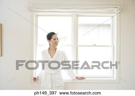 Young woman leaning against a window View Large Photo Image Stock Photo - Young woman leaning against a window. Fotosearch