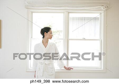 Young woman leaning against a window View Large Photo Image Stock Photo - Young woman leaning against a window. Fotosearch