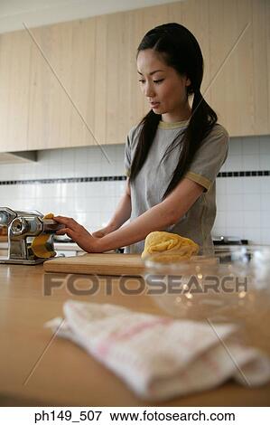 Young woman preparing food in the kitchen View Large Photo Image Stock Photo - Young woman preparing food in the kitchen. Fotosearch