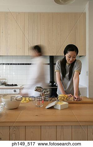 Young woman preparing food in the kitchen View Large Photo Image Stock Photo - Young woman preparing food in the kitchen. Fotosearch