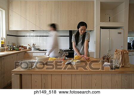 Young woman preparing food in the kitchen View Large Photo Image Stock Photo - Young woman preparing food in the kitchen. Fotosearch