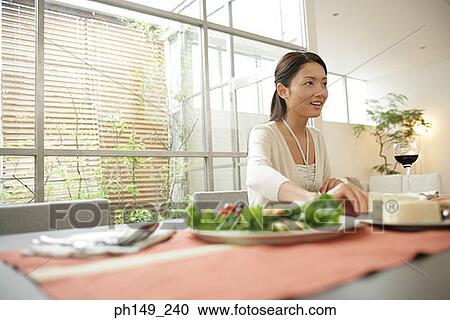 Young woman sitting at the dining table View Large Photo Image Stock Image - Young woman sitting at the dining table. Fotosearch