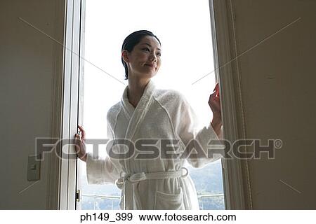 Young woman standing at the doorway and smiling View Large Photo Image Stock Photo - Young woman standing at the doorway and smiling. Fotosearch