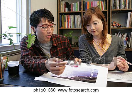 Businessman and a businesswoman looking at a photograph View Large Photo Image Stock Image - Businessman and a businesswoman looking at a photograph. Fotosearch