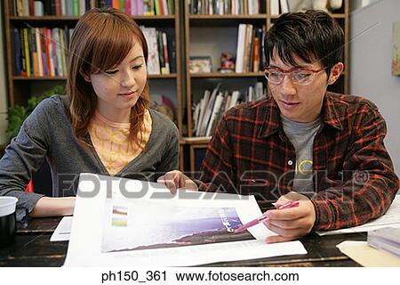 Businessman and a businesswoman looking at a photograph View Large Photo Image Stock Image - Businessman and a businesswoman looking at a photograph. Fotosearch