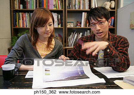 Businessman and a businesswoman looking at a photograph View Large Photo Image Stock Image - Businessman and a businesswoman looking at a photograph. Fotosearch