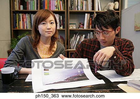Businessman and a businesswoman looking at a photograph View Large Photo Image Stock Image - Businessman and a businesswoman looking at a photograph. Fotosearch