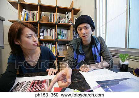 Businessman and a businesswoman sitting in an office View Large Photo Image Stock Image - Businessman and a businesswoman sitting in an office. Fotosearch