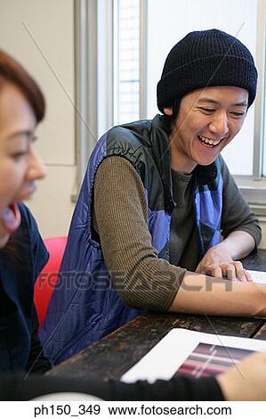 Stock Photo - Businessman and a businesswoman sitting in an office. Fotosearch