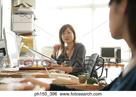 Businesswoman talking to a colleague View Large Photo Image Stock Photograph - Businesswoman talking to a colleague. Fotosearch