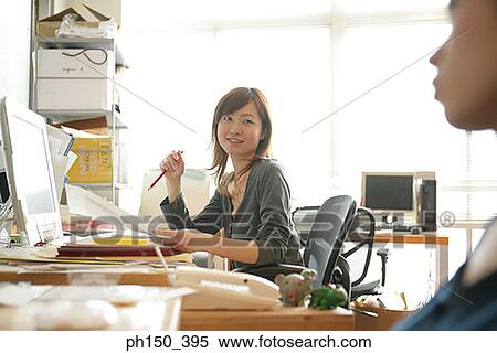 Businesswoman talking to a colleague View Large Photo Image Stock Photography - Businesswoman talking to a colleague. Fotosearch