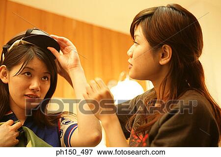 Close-up of a fashion designer assisting a female fashion model in a dressing room View Large Photo Image Stock Photo - Close-up of a fashion designer assisting a female fashion model in a dressing room. Fotosearch