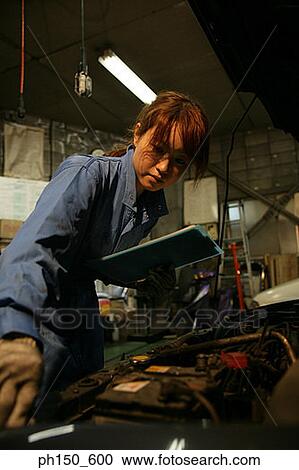 Close-up of a female auto mechanic examining an engine View Large Photo Image Stock Image - Close-up of a female auto mechanic examining an engine. Fotosearch
