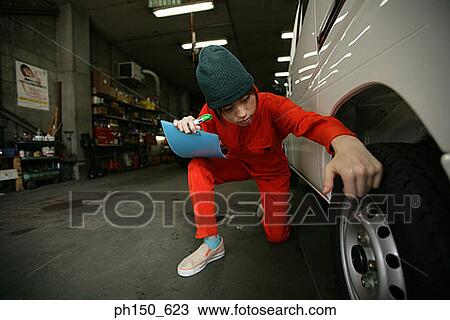 Close-up of a female auto mechanic examining a wheel View Large Photo Image Stock Image - Close-up of a female auto mechanic examining a wheel. Fotosearch