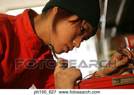 Close-up of a female auto mechanic holding work tools View Large Photo Image Stock Photo - Close-up of a female auto mechanic holding work tools. Fotosearch