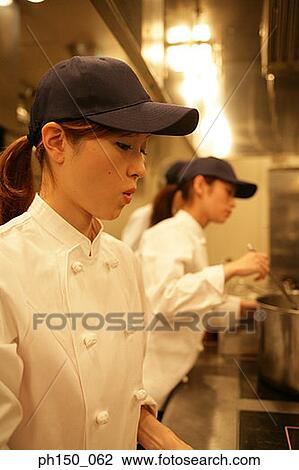 Close-up of a female chef preparing food with her colleagues View Large Photo Image Stock Image - Close-up of a female chef preparing food with her colleagues. Fotosearch